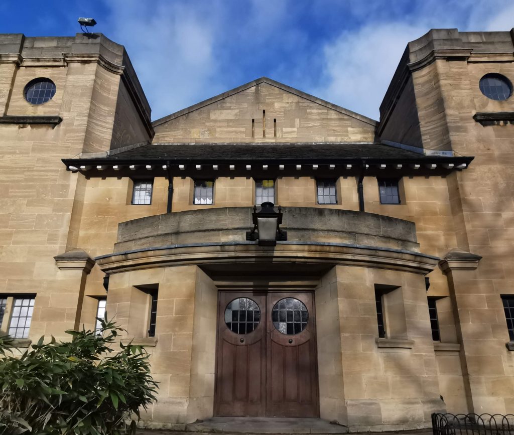 View of stone building from low angle. Blue sky is showing at top of image.